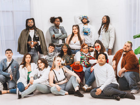 A group of diverse models posed on and around a couch.