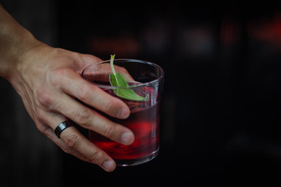 Person holding a PB Negroni cocktail drink