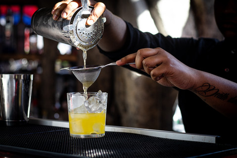 Bartender preparing a golden yellow cocktail 