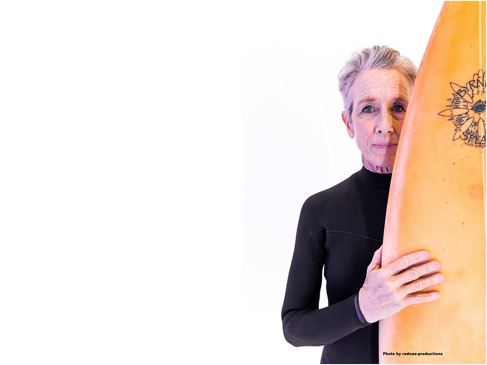 Woman over 45 holding her surfboard