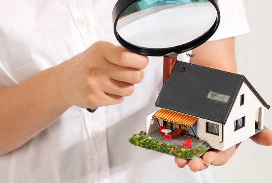 person looking at a house under a magnifying glass