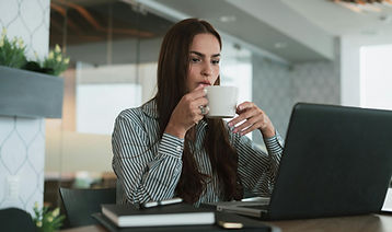 Woman at a laptop thinking