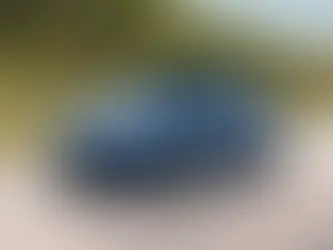 Blue Volkswagen Jetta on the highway in a rural mountain area