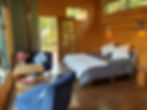 View from the kitchenette in Protea Cabin of warm natural light on the wooden walls and soft finishes