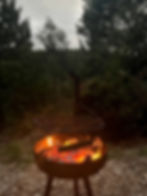 Burning fire bowl with grill grate outdoors after sunset