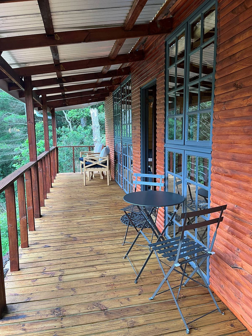 External deck of Waterfall Cabin, with tables and chairs, and windows