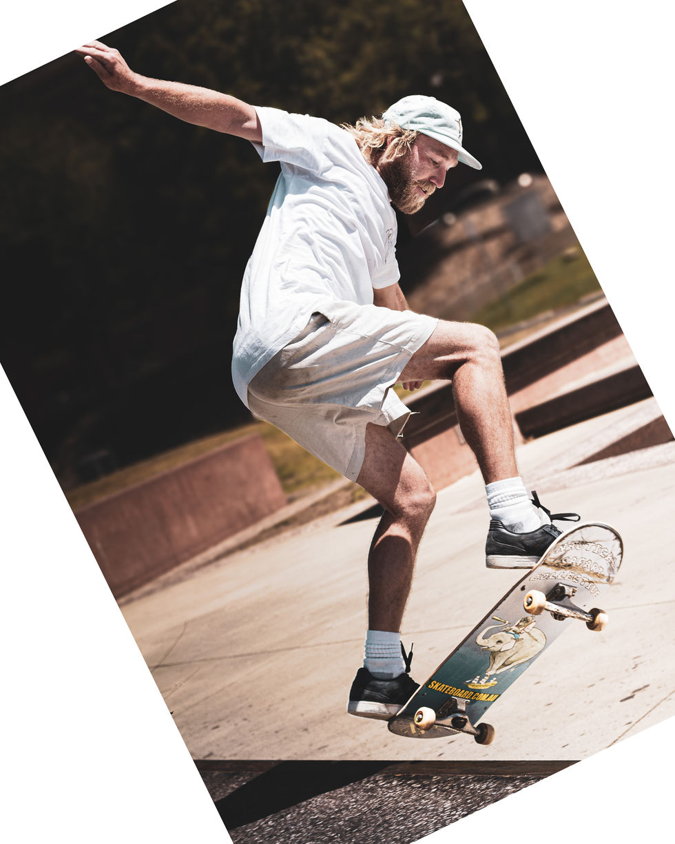 Skateboarder en plein saut réalisant une figure de ollie dans un skatepark à Brisbane, Australie.