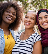 Group of three happy multiethnic friends looking at camera. Portrait of young women of dif