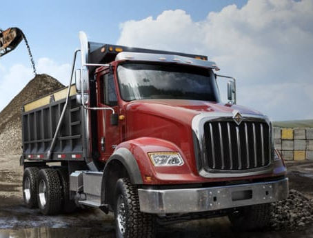 Vocational dump truck chassis, the same platform category used for roll-off cable hoist and hook-lift container systems in demolition and C&D hauling
