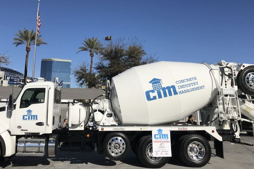 Kenworth T880S concrete mixer truck charging hopper, the point where spinner guards catch slurry sling-off during drum loading.