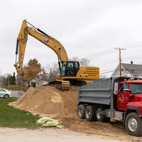 CAT excavator on a major highway reconstruction project, the kind of work delivered through public-private partnership megaprojects like Florida's I-4 Ultimate