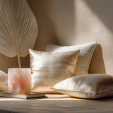 Luxury meditation corner with a beige Venetian plaster wall, cream, rose quartz, and champagne satin pillows, paper fan décor, greenery, and a pink Himalayan salt lamp on a journal.