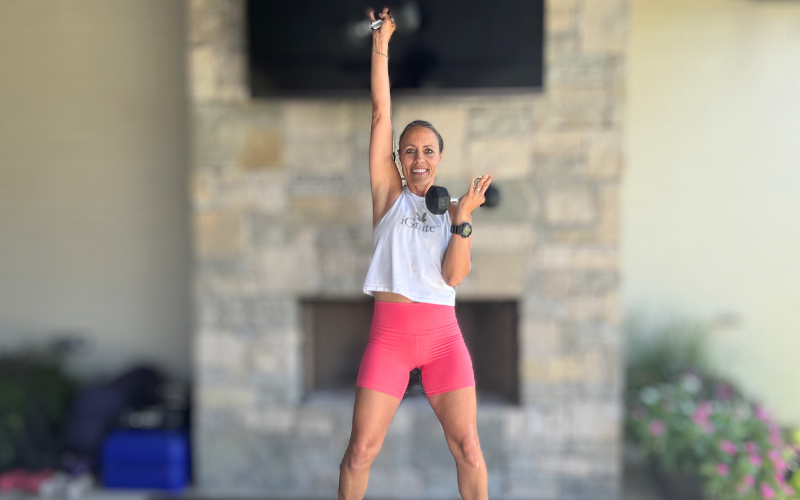 Founder, Neissa Springmann, smiling while doing an overhead press
