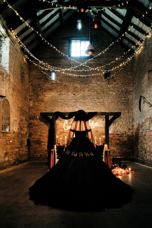 till death do us part black and gold embroidered veil with black tulle ballgown wedding dress, ruffle hem, feather lace bodice and off the shoulder sleeves.