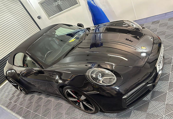Black Porsche sports car on a checkered floor