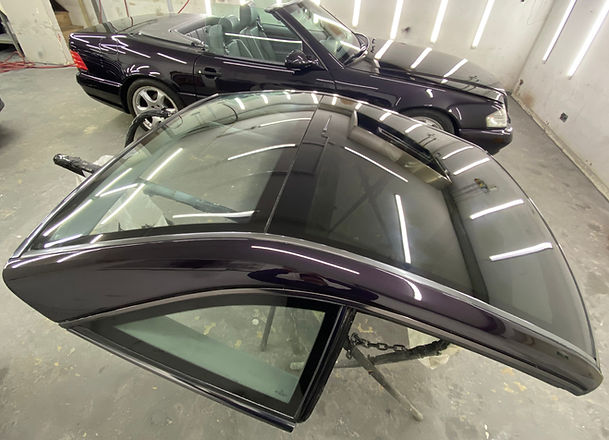 Detached dark hardtop with sunroof next to matching convertible
