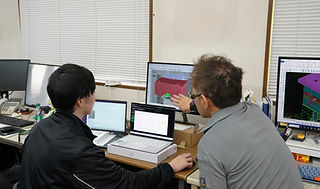 パソコン画面を見ながら話し合う従業員たち.jpg