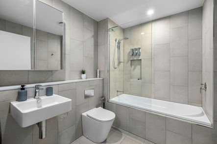 A spacious bathroom with durable floor and wall tiles, designed for high-moisture areas.