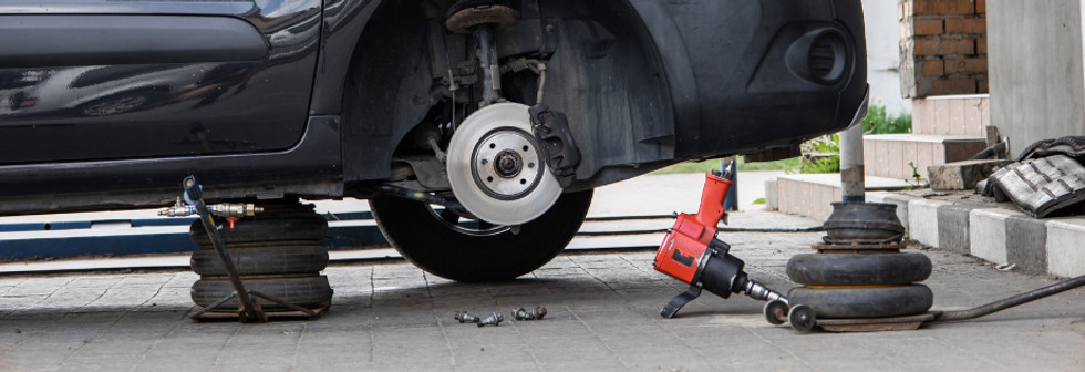 Mobile brake service mechanic repairing a car brake system on-site in Rexburg and East Idaho