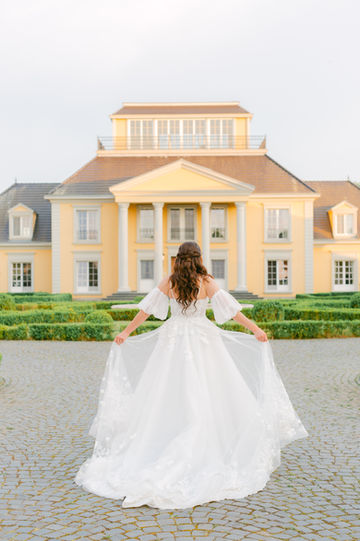 Braut mit Brautkleid vor Hochzeitslocation