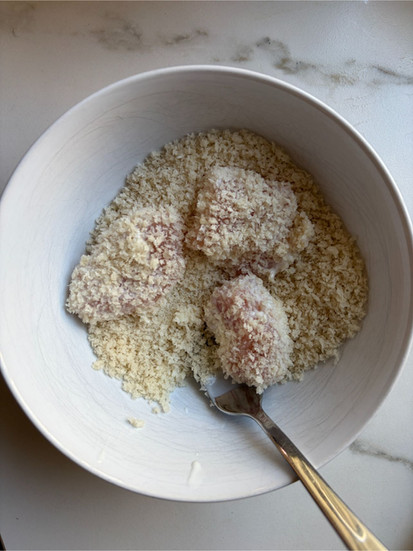 Adding panko as coating to the chicken for the crispy salad topping