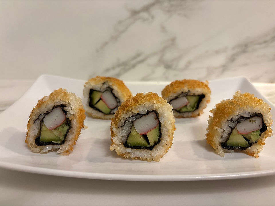 Fried surimi uramaki sushi rolls presented on a plate from an alternative angle