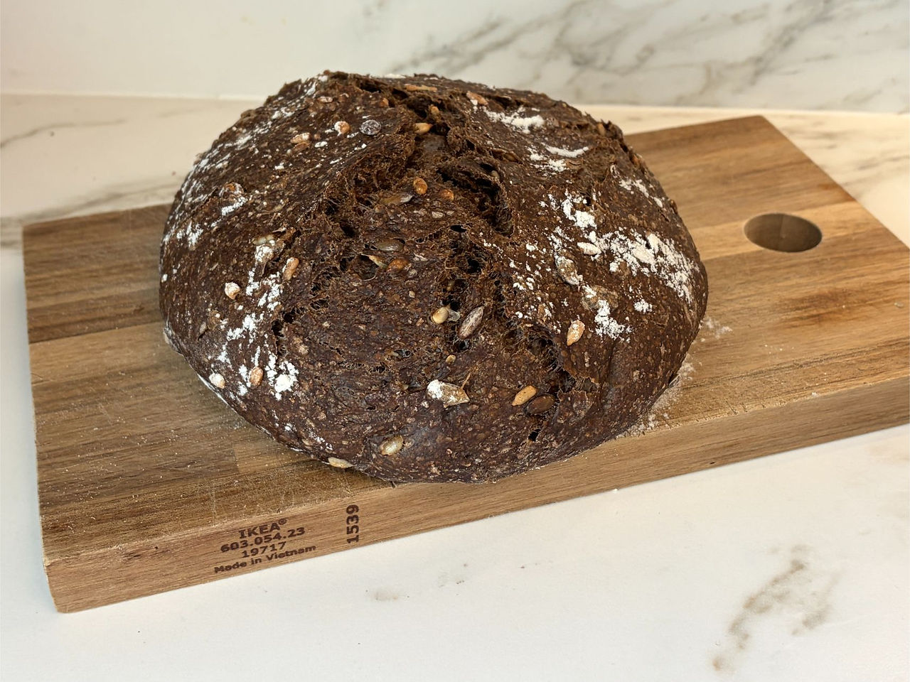 Homemade whole wheat sourdough bread on cutting board ready to eat showing firm crumb and rustic crust