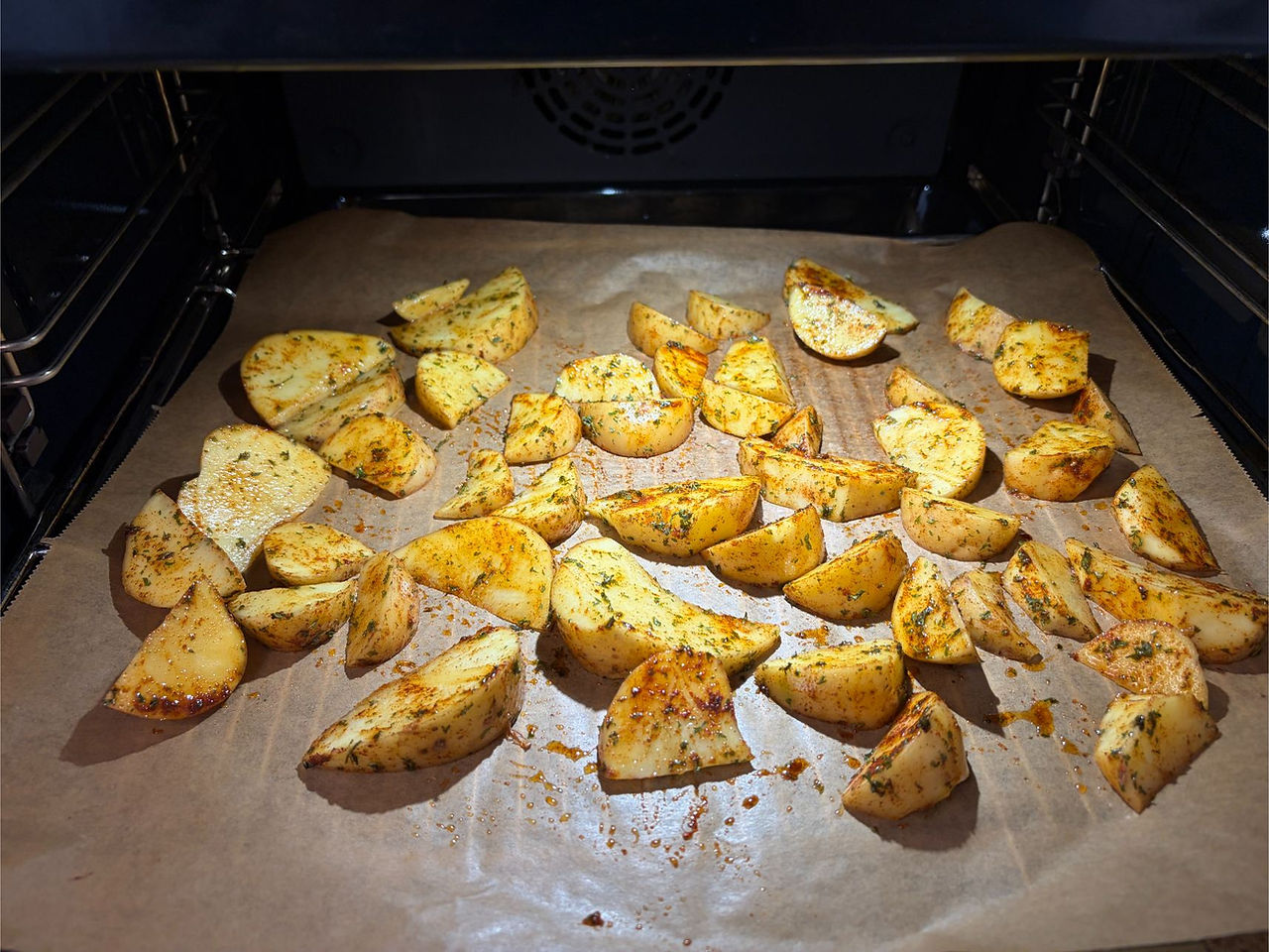 Seasoned homemade potato wedges arranged on a baking tray before oven roasting