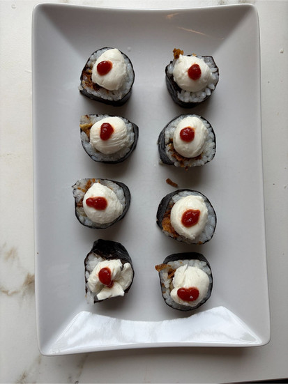 Adding mini mozzarella and sriracha lava topping to Oyster Mushroom Lava Roll Sushi before grilling