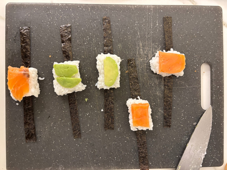placing the avocado and salmon on the rice nigiri blocks