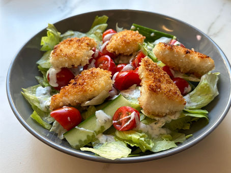 Chicken salad ready to serve with golden panko chicken and fresh vegetables