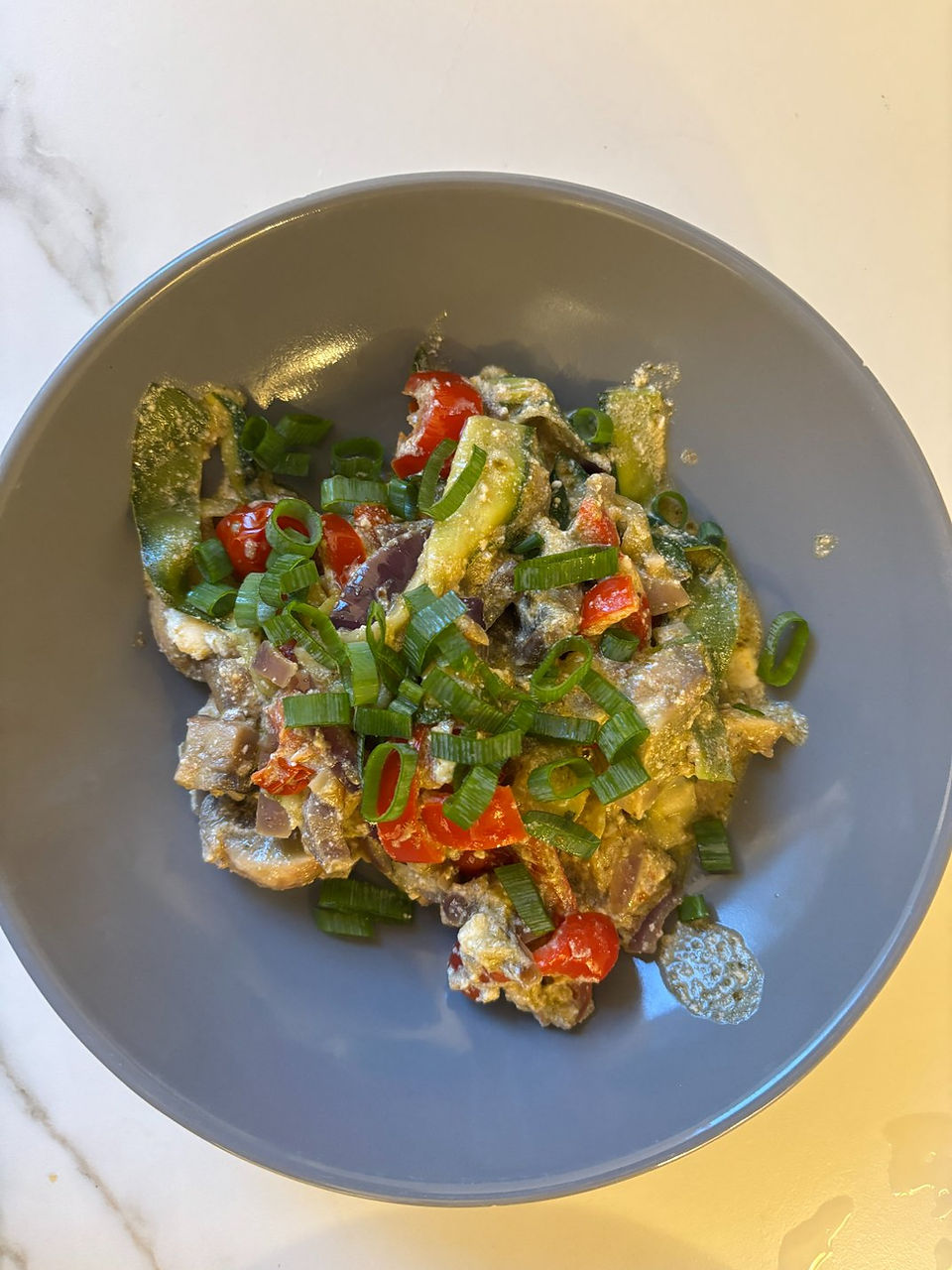 final presentation of zucchini pesto noodles plated with fresh herbs