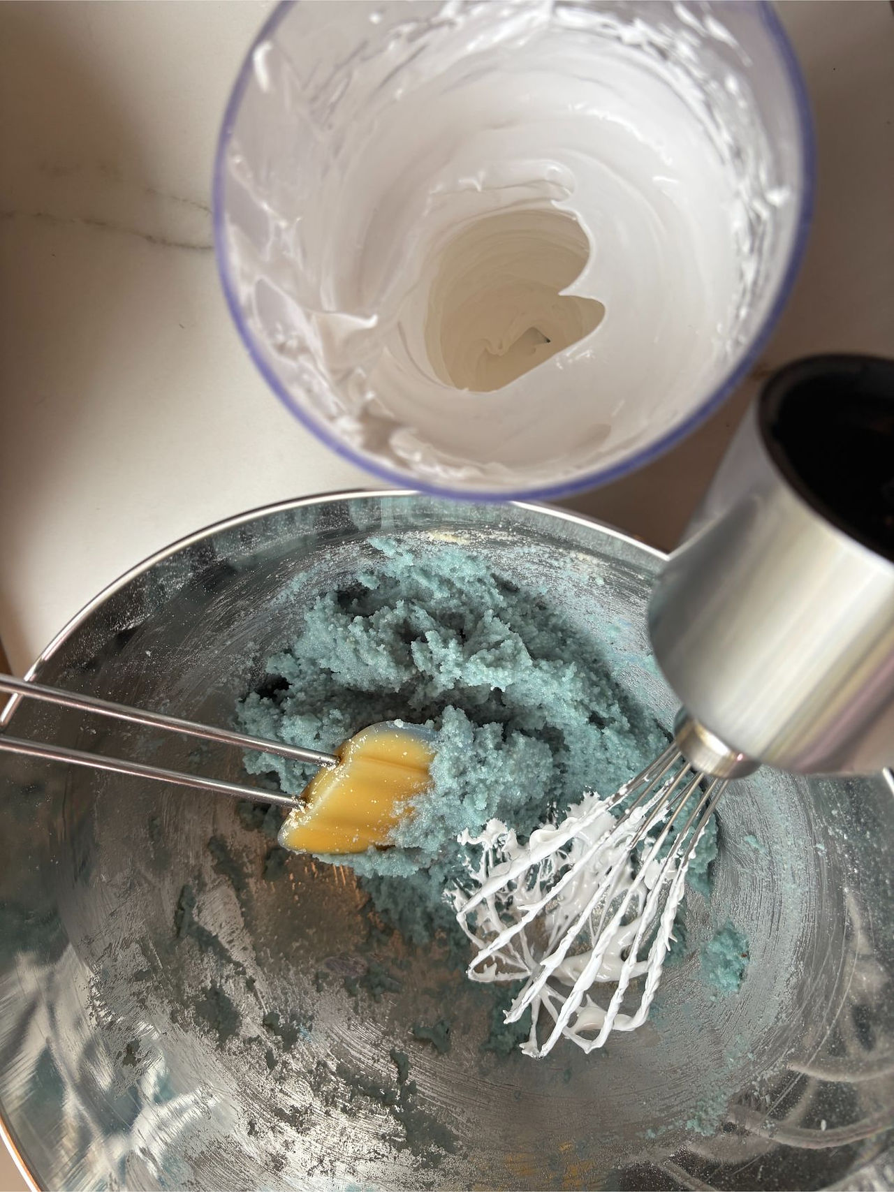 Adding meringue to almond paste to start the macaronage