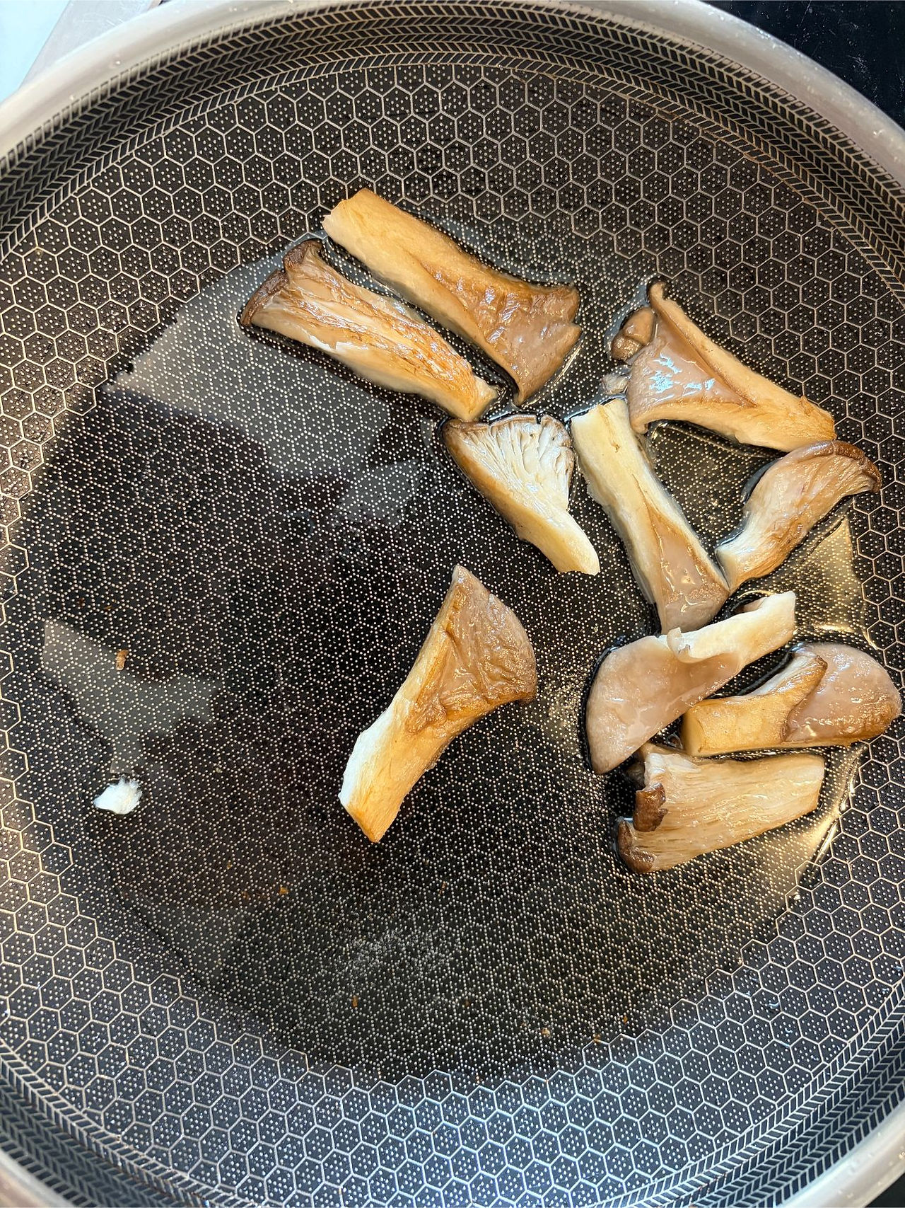 Oyster mushrooms frying in a pan until golden brown for homemade vegetarian sushi rolls