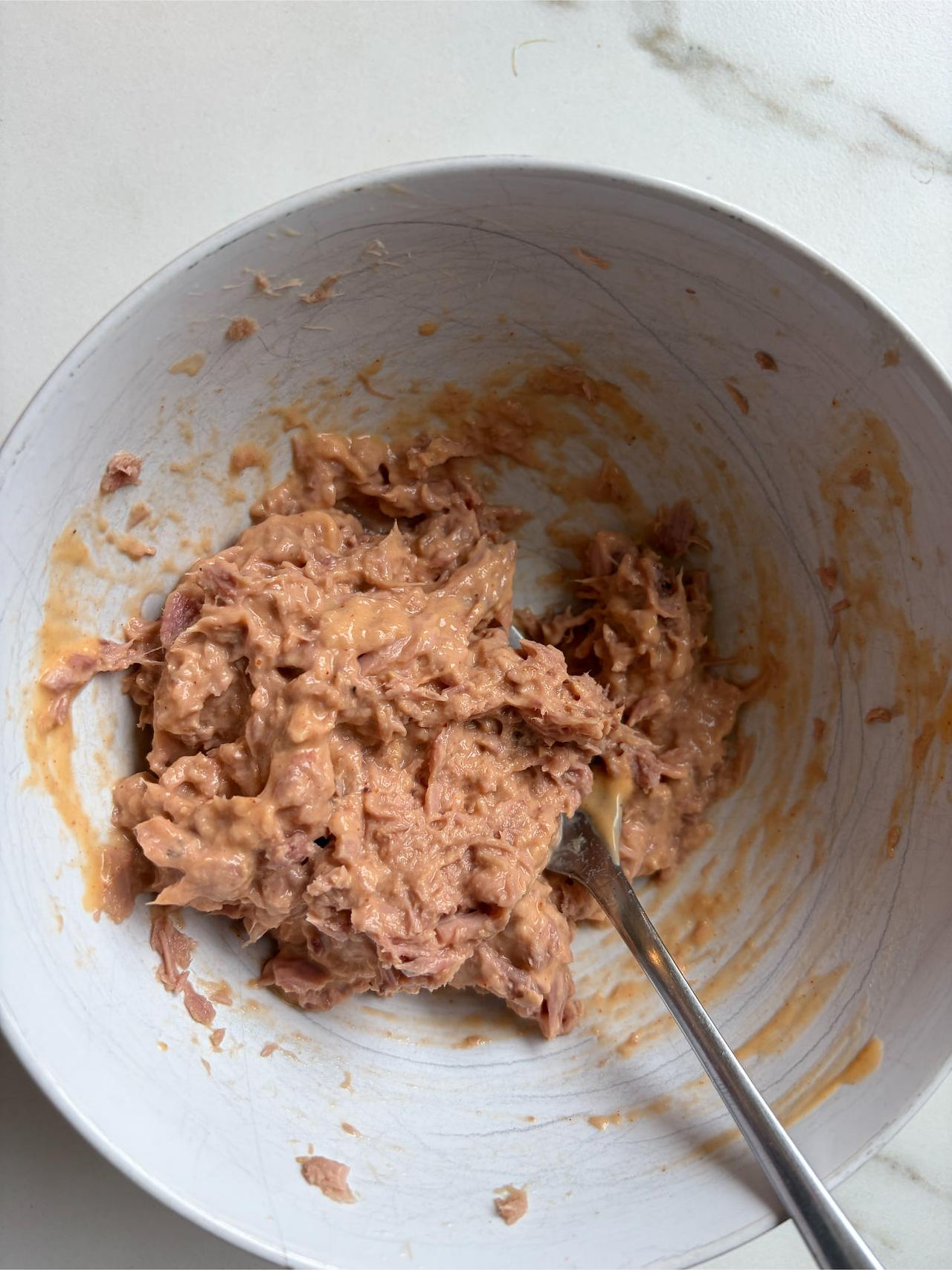 Adding cocktail sauce to tuna while making a creamy tuna mousse appetizer