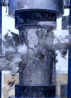 Concrete compressive strength characteristic test showing a concrete sample or pipe undergoing destructive pressure testing.