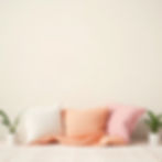 Peach, pink, white pillows on bed