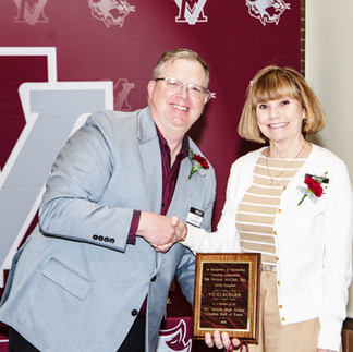 Vicki Rueger accepts the M-Club Hall of Fame Award