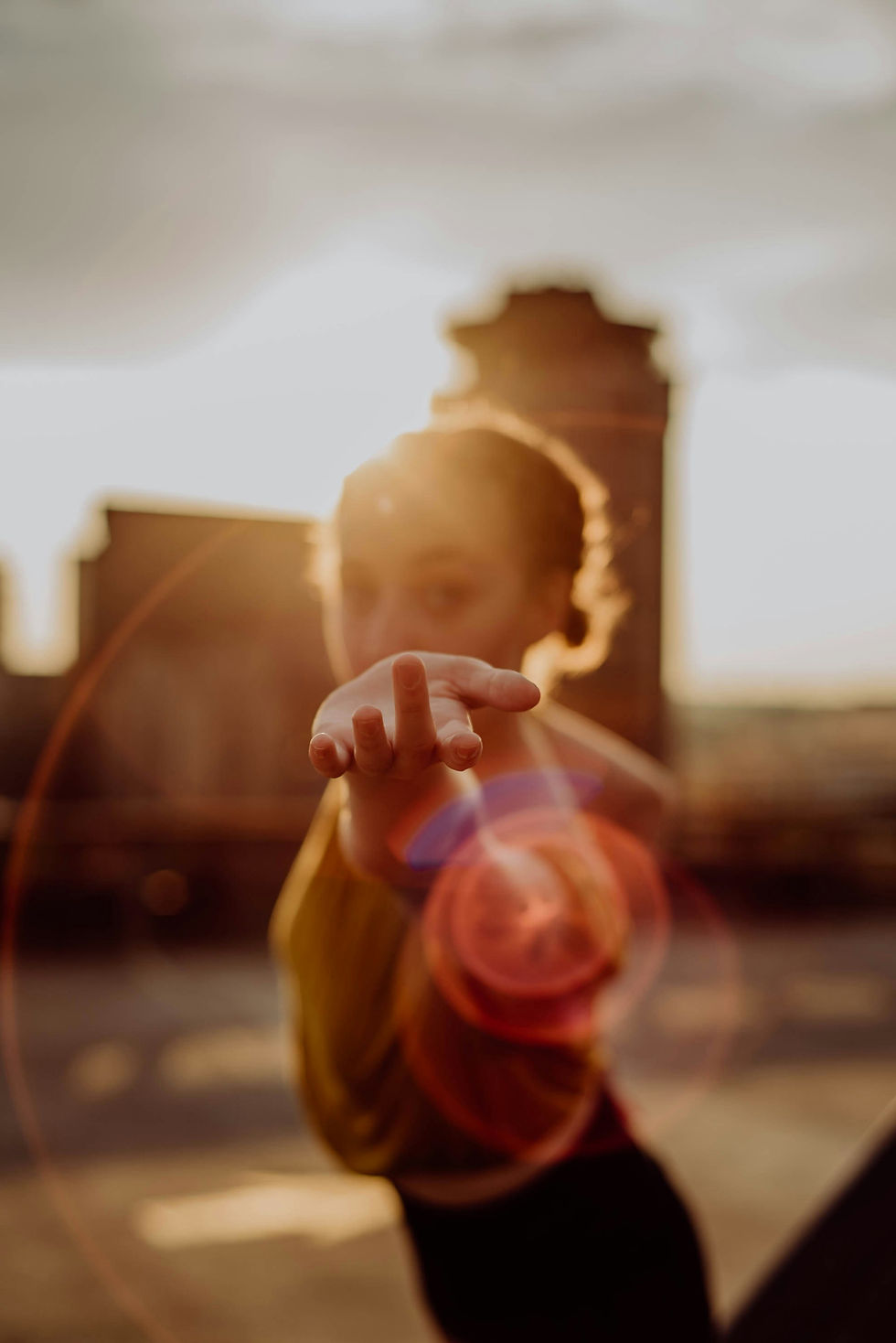 Woman reaching toward the viewer to invite them in to the light