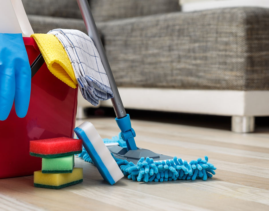 Cleaning Materials. A mop, a pile of sponge scrubbers, gloves and a red bucket 