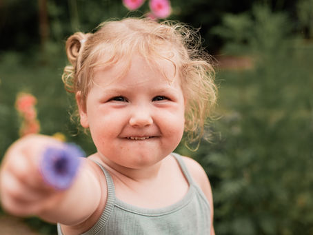 little-girl-with-purple-flower-close-up