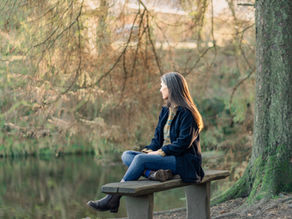 Midlife woman resting outdoors in warm clothing during perimenopause, reflecting on nervous system balance and recovery