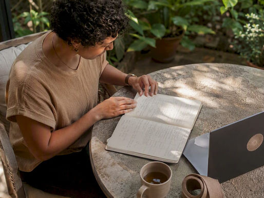 Person reviewing yoga class notes at home table
