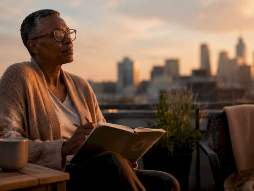 Person journaling in sunlight on balcony