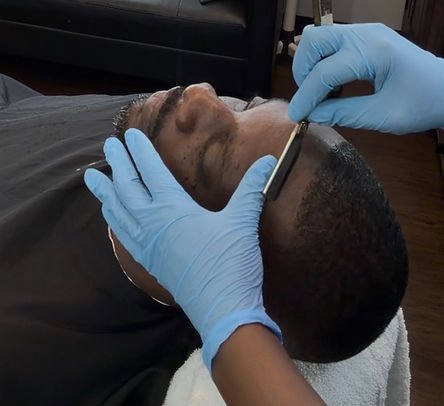 Photo of COME.iLL lining up a client's hairline