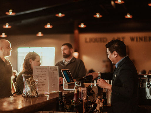 A bartender pours a drink for a guest of the winery in the Event Center.
