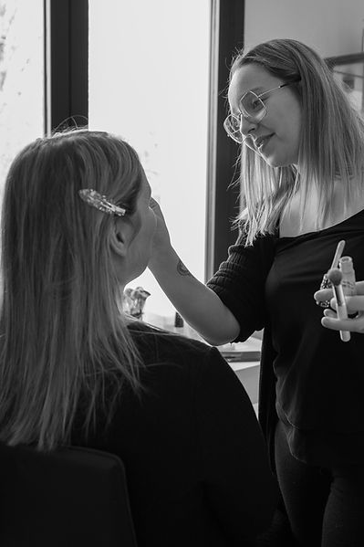 Maquilleuse qui effectue une mise en beauté d'une cliente avant une séance photo près de Bain de Bretagne