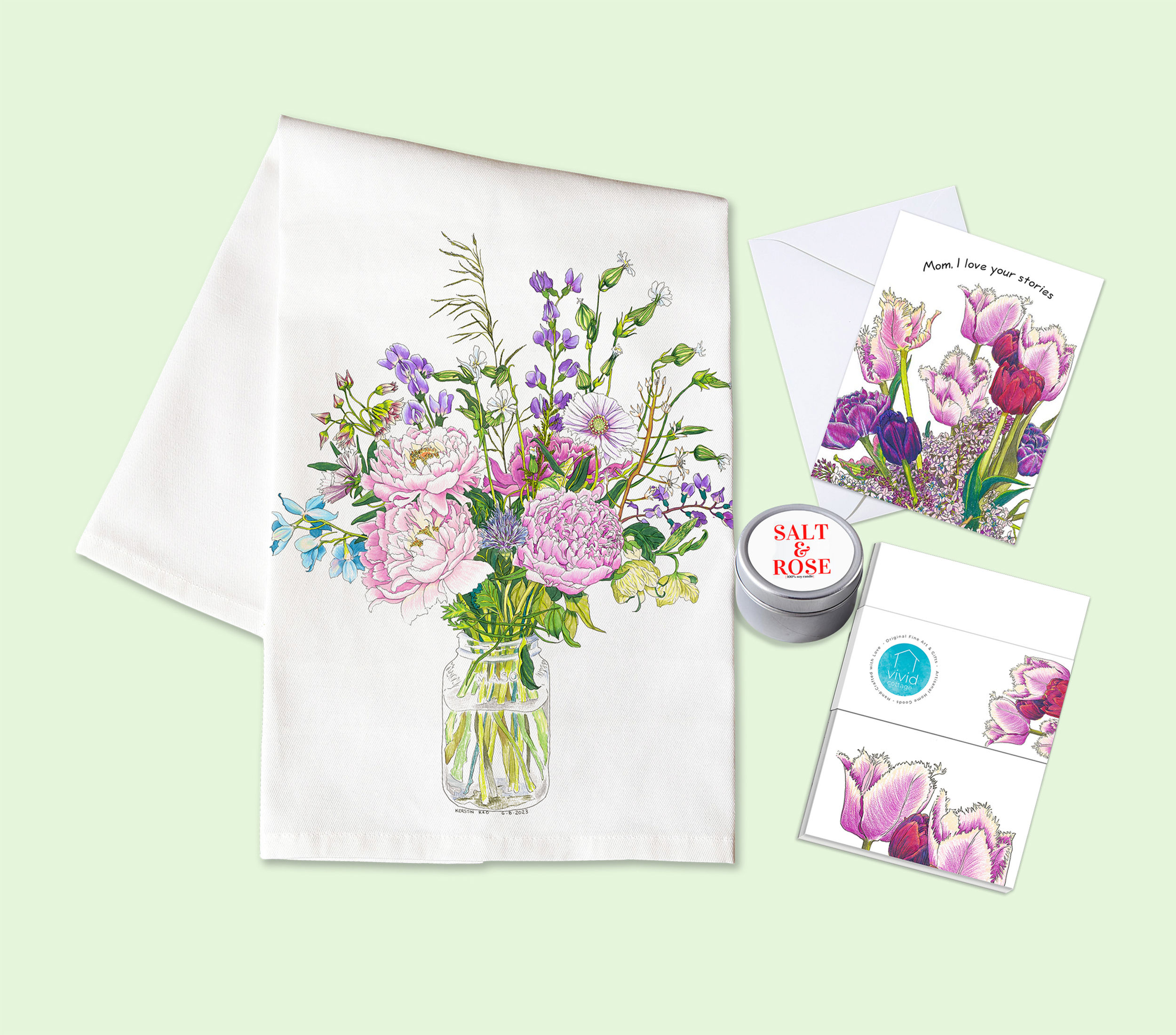 Top view of floral tea towel, notepad, candle, and Mother's Day greeting card