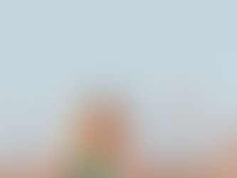 A woman walking, carrying something on her back and smiling