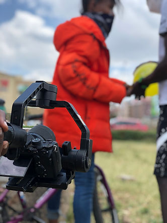 A camera in the foreground recording 2 blurred figures in the background